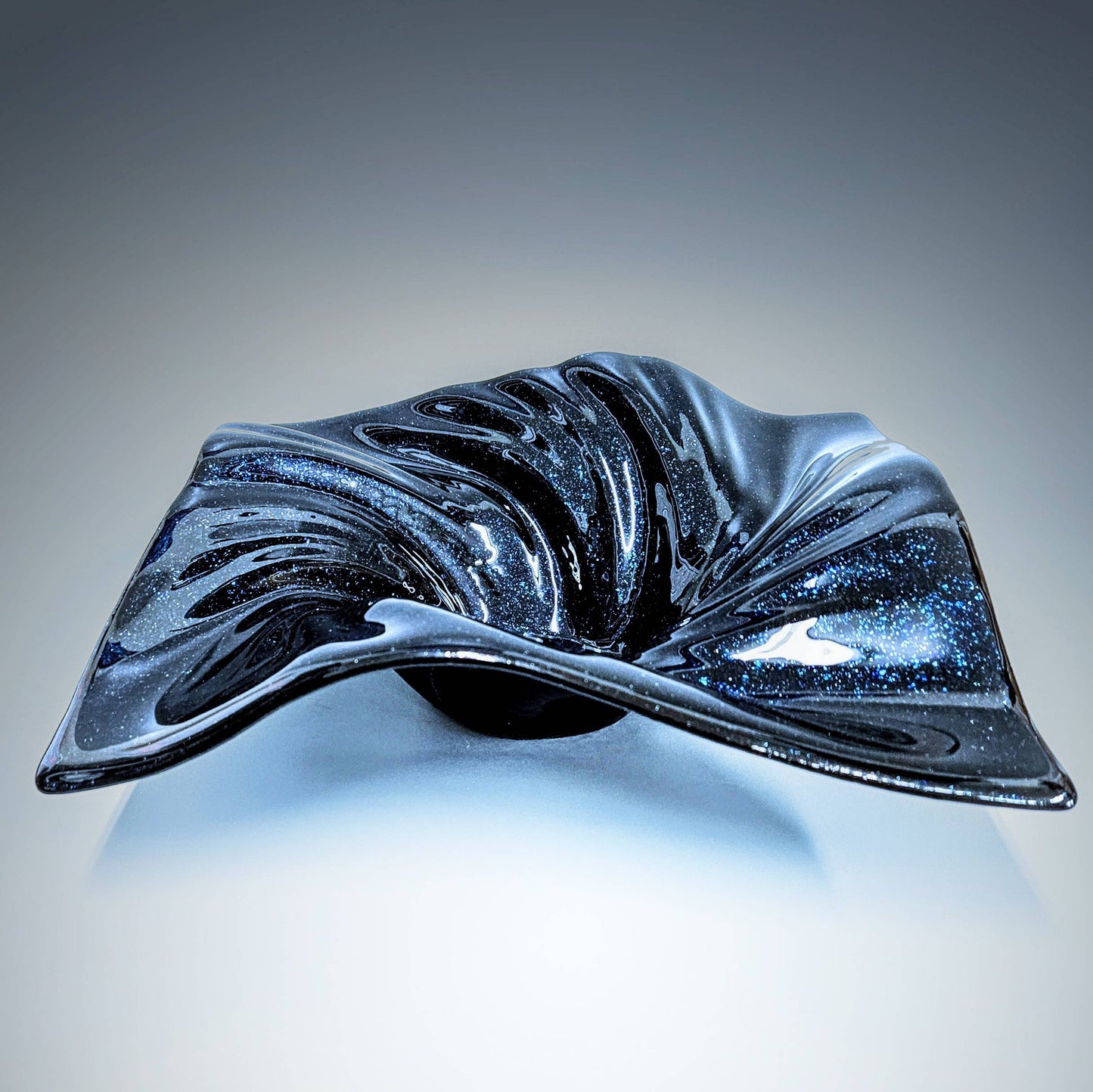 This stunning midnight blue aventurine fused glass bowl was handcrafted in the heart of Cincinnati, Ohio. The deep, velvety hue of midnight blue dances gracefully across the smooth surface of the bowl, evoking a sense of mystery and elegance.