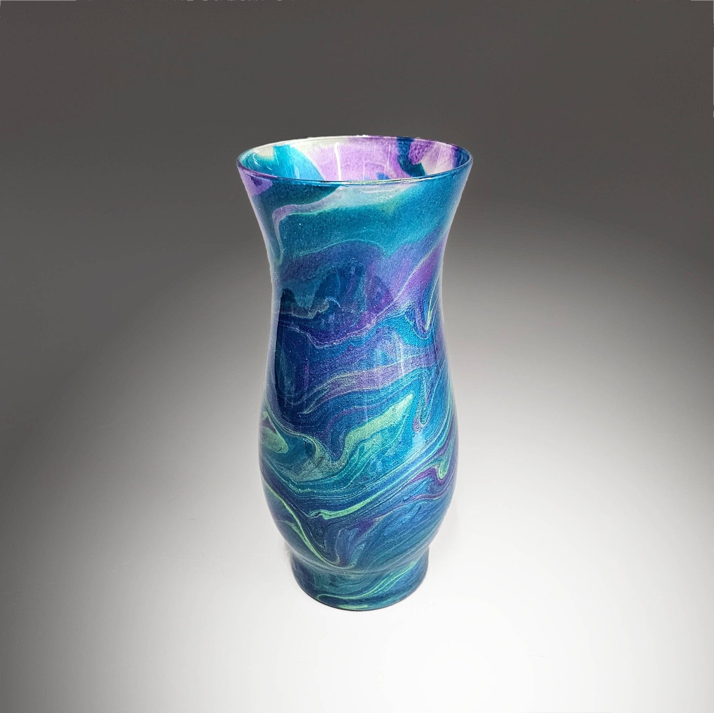 This abstract, painted glass vase is the perfect accent piece for any décor. Unique and one-of-a-kind, you're sure to get many compliments on this unique design. Done in a striking mix of metallic teal, purple and gold, it was hand painted, then sealed with multiple coats of high gloss 