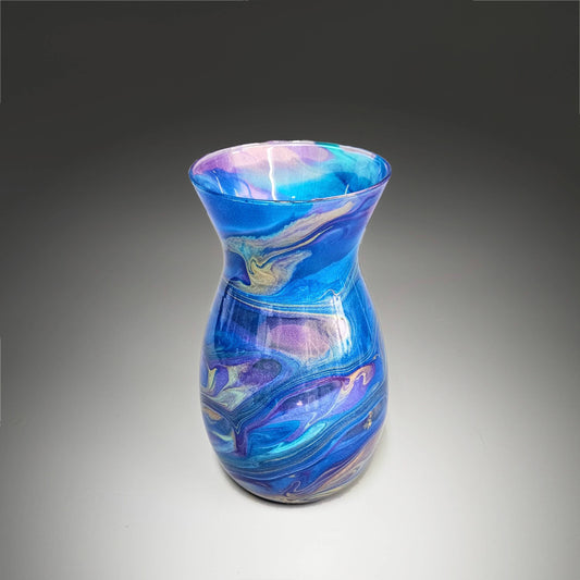This hand-painted, fluid art, modern glass vase is a festive display of vibrant colors swirling together in an elegant dance of purple, gold, aqua, and blue. The fluidity of the design creates a captivating and unique pattern, each curve and blend of color telling its own story.
