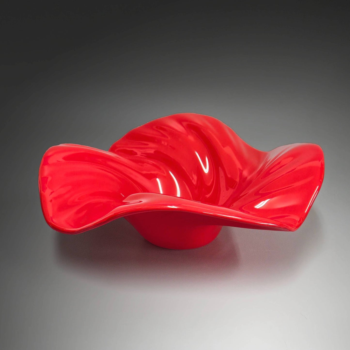 This beautiful glass wave bowl is done in striking shade of bright scarlet red. It's done in an opaque glass which lets the light play off it beautifully.