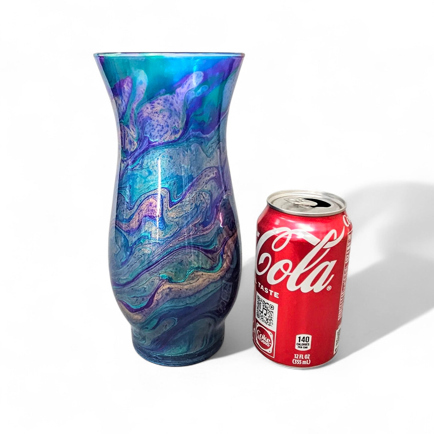 This abstract, peacock feather painted glass vase is the perfect accent piece for any décor.