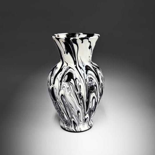 This hand-painted, abstract centerpiece vase, in black and white, is an arresting piece of art that captivates with its bold, modern aesthetic. Its striking design transcends traditional boundaries, offering a timeless appeal suitable for diverse tastes and decor styles.