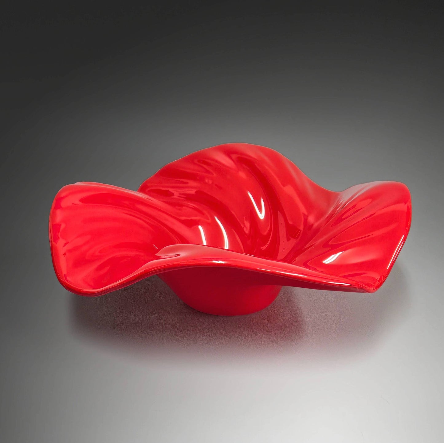 This beautiful glass wave bowl is done in striking shade of bright scarlet red. &nbsp;It's done in an opaque glass which lets the light play off it beautifully.